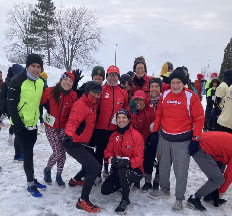 Les membres du club Boréal, en manteaux d’hiver, réunis dans la neige après une sortie.